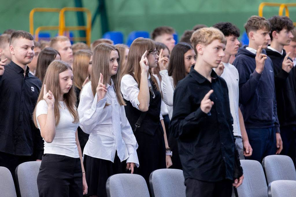Uczniowie klas pierwszych podczas ślubowania w hali sportowej.