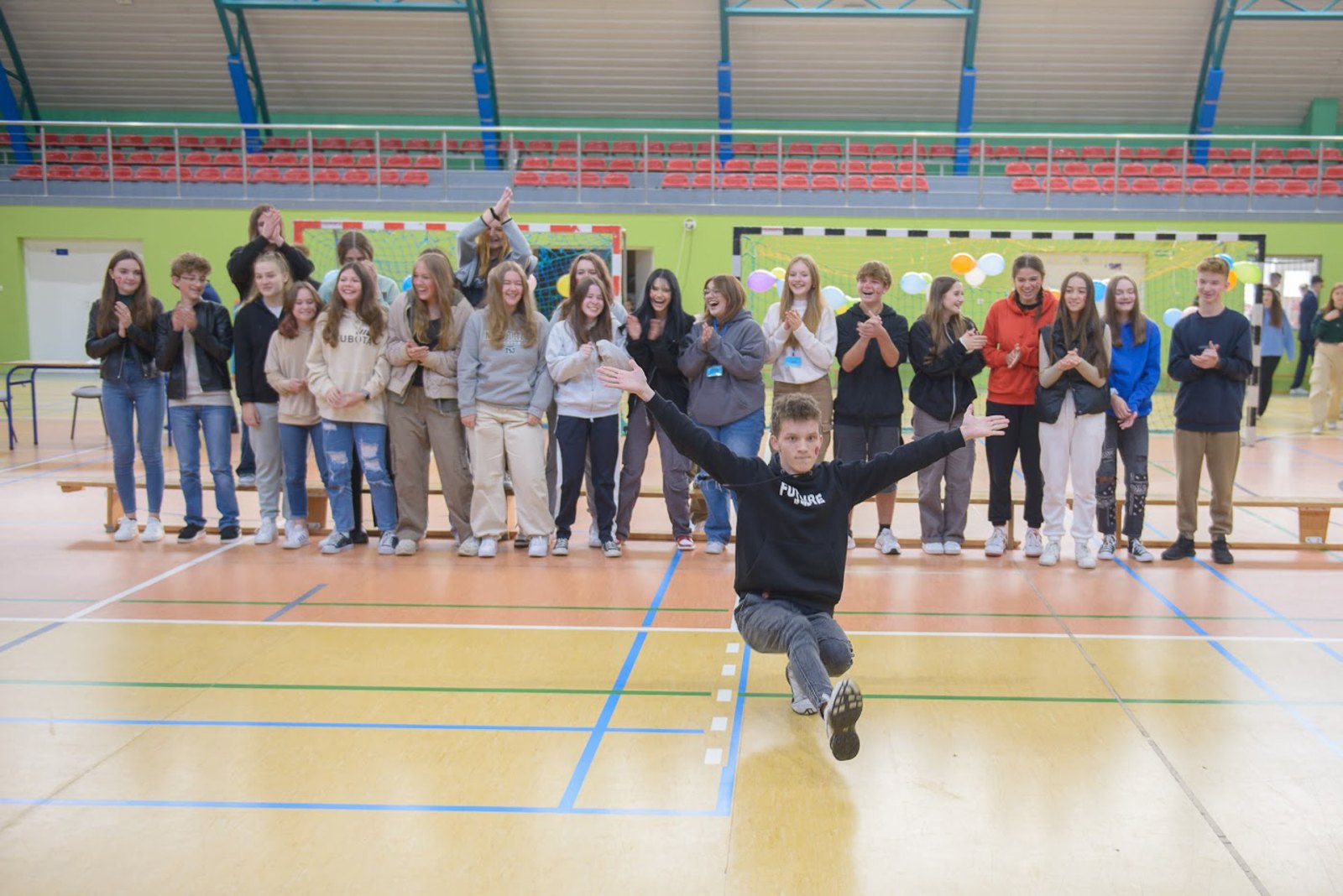 Uczniowie bawią się wspólnie podczas otrzęsin w hali sportowej.