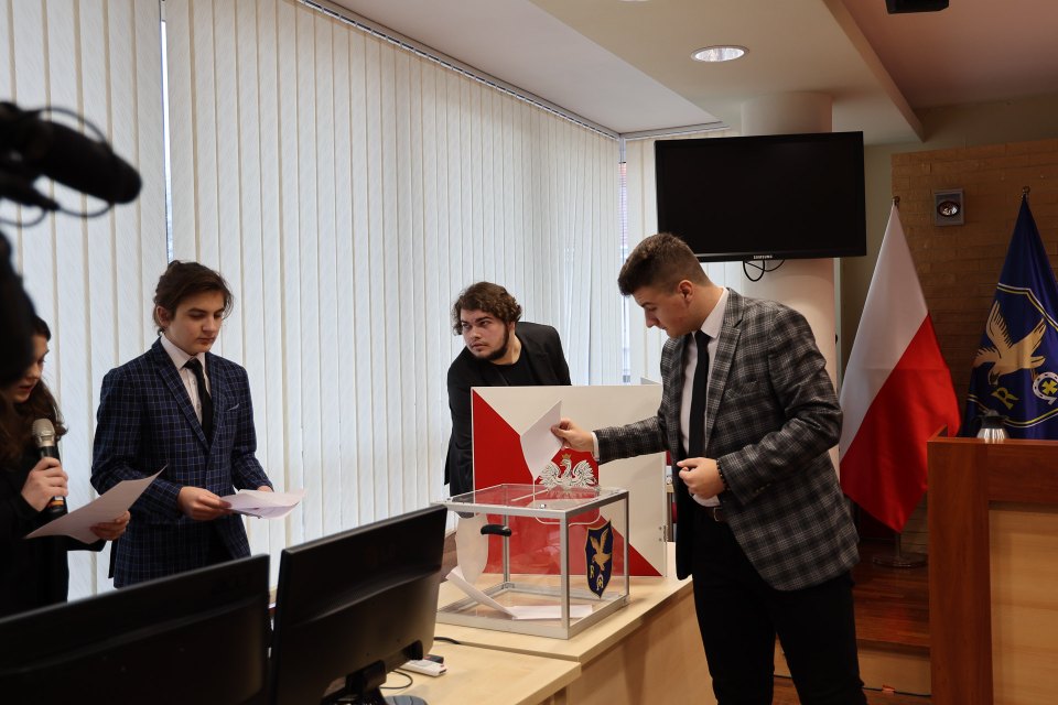 Głosowanie przy przezroczystej urnie podczas posiedzenia rady.