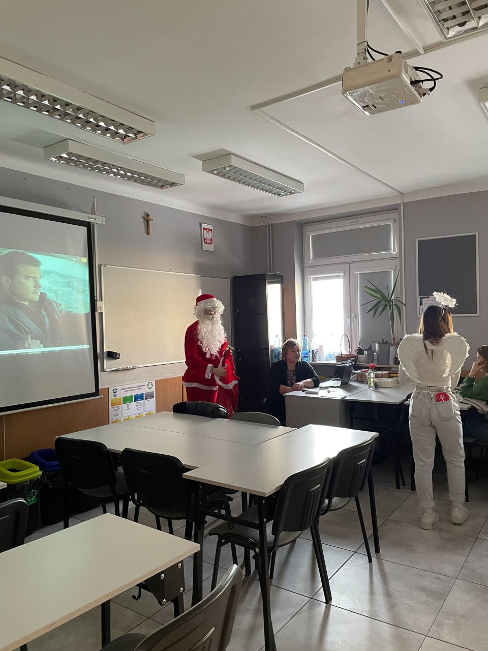 Mikołaj i pomocniczka spotykają się z uczniami w klasie.