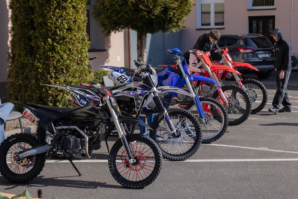 Rząd motocykli przygotowanych do pokazu przed szkołą.