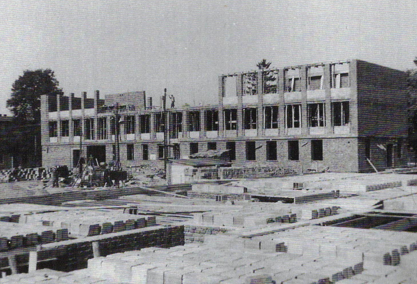 Budowa budynku A szkoły w latach 1960–1964. Widoczne wznoszone kondygnacje i materiały budowlane.