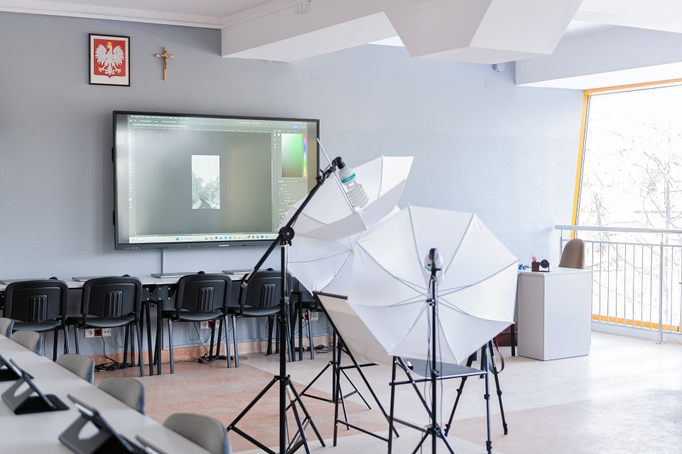 Stanowisko do fotografowania z białym parasolem i lampami.