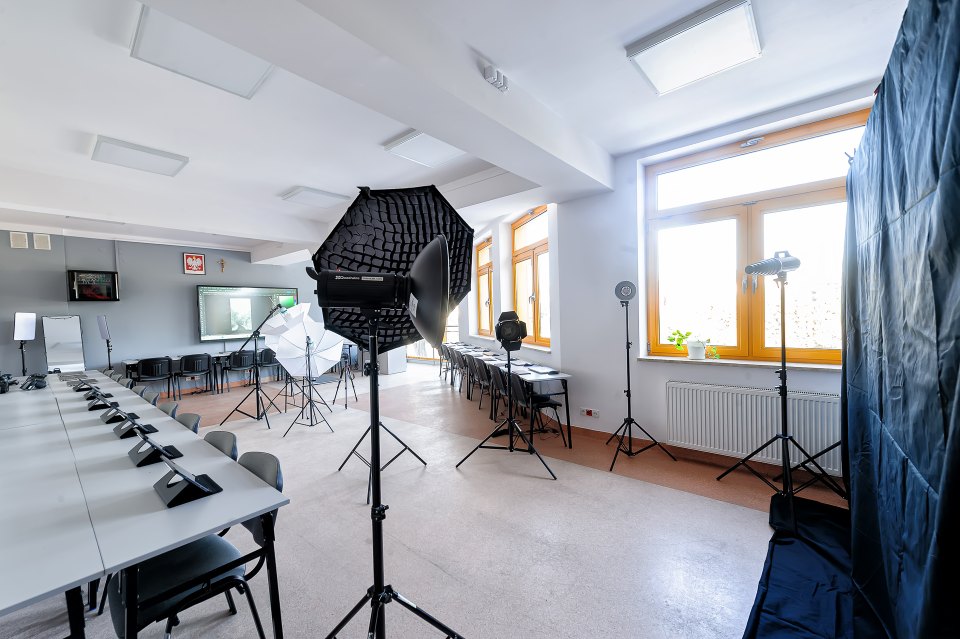Lampy studyjne i komputery ustawione wzdłuż sali.