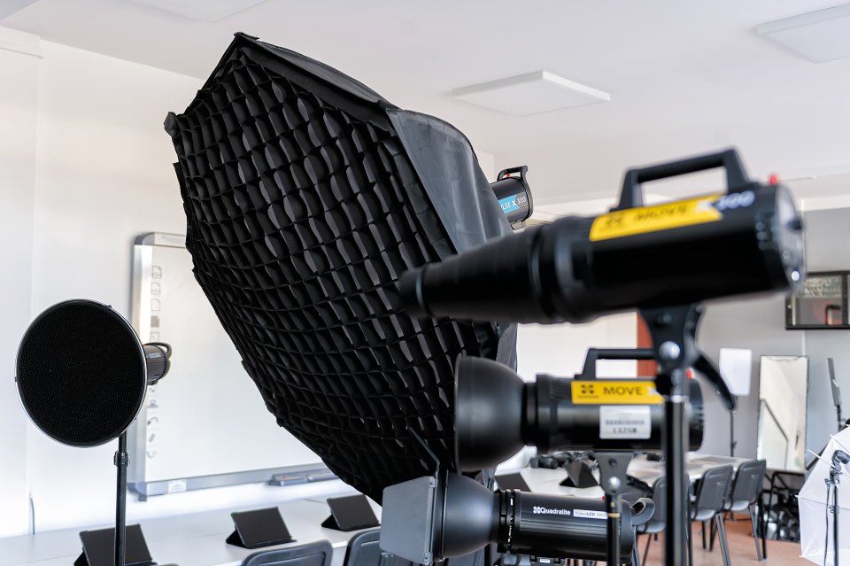 Zbliżenie zestawu lamp fotograficznych i softboksu.