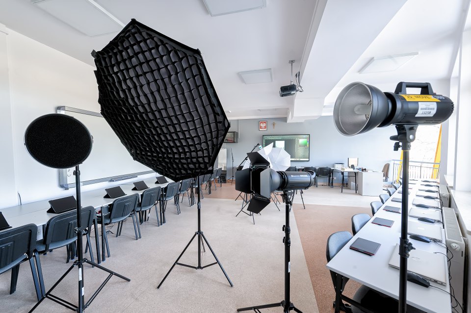 Zbliżenie lampy i softboksu w pracowni fotograficznej.