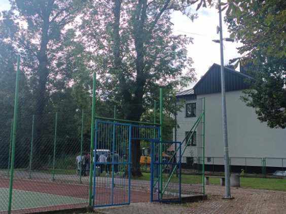 Uczniowie sprzątają otoczenie boiska.