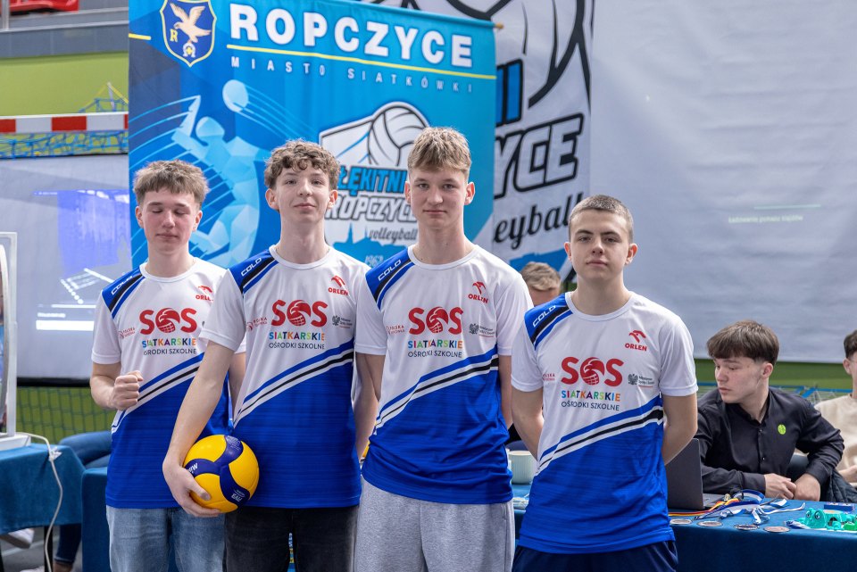 Uczniowie w strojach sportowych prezentują szkolne stoisko siatkarskie.