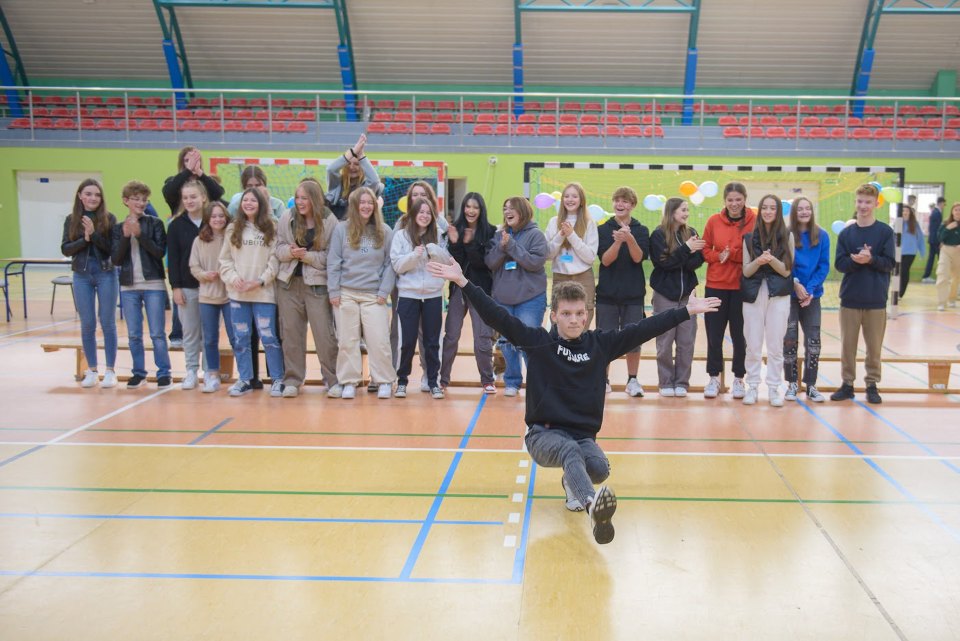 Uczniowie bawią się wspólnie podczas otrzęsin w hali sportowej.