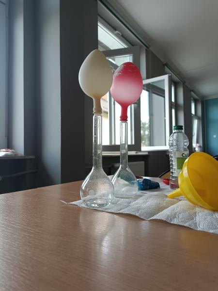 Dwie kolby z balonami na stanowisku doświadczeń chemicznych.
