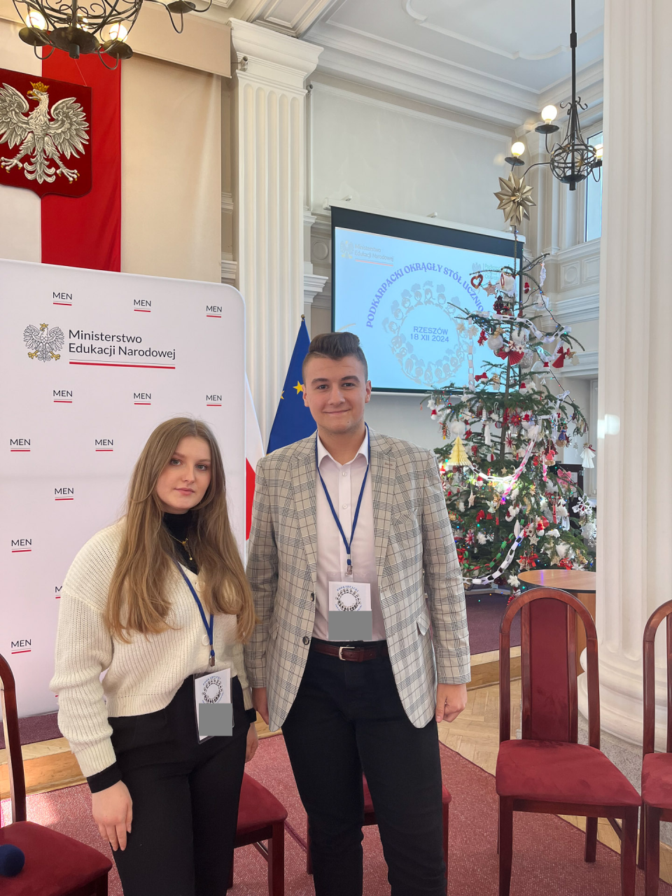 Dwoje uczestników Okrągłego Stołu pozuje w sali obrad.