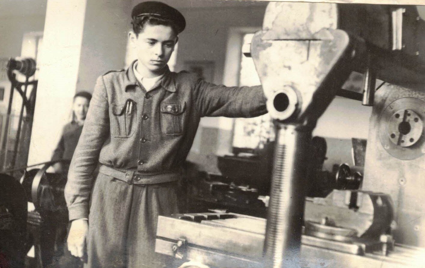 Archiwalne zdjęcie ucznia przy obrabiarce w szkolnym warsztacie, rok szkolny 1954/1955.