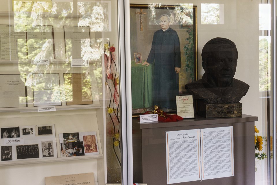 Portret i popiersie patrona szkoły obok ekspozycji historycznej.