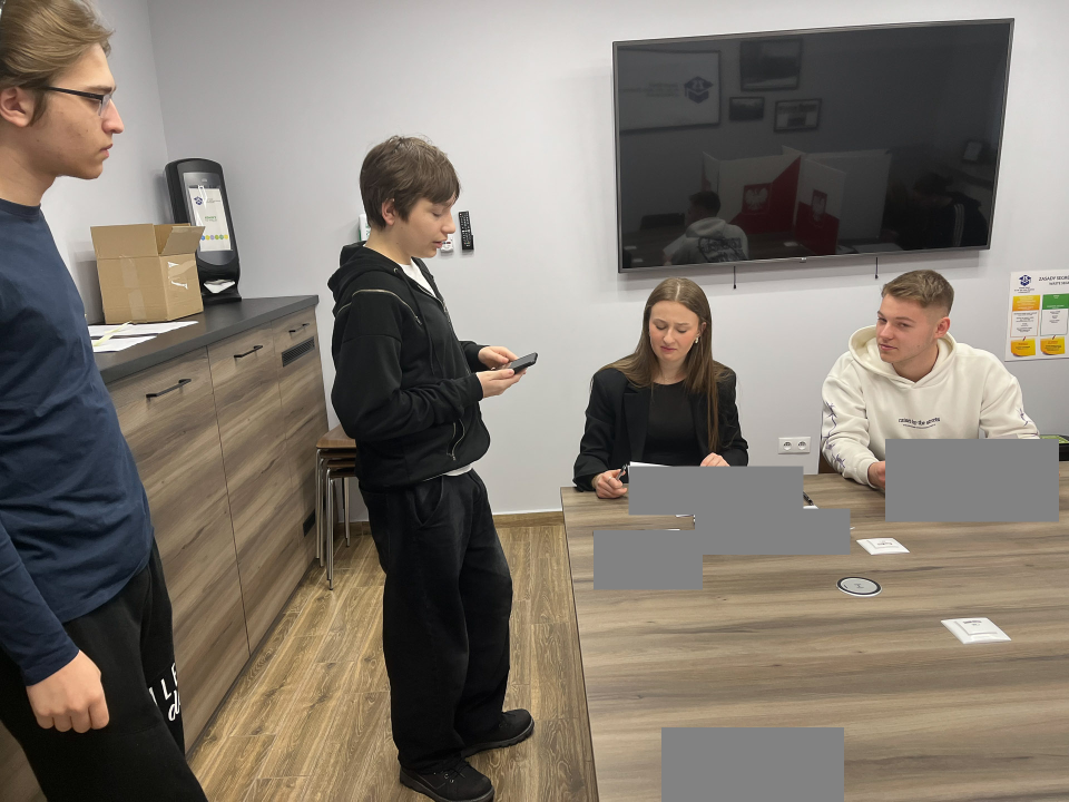 Uczestnicy wyborów podchodzą do stolika komisji.