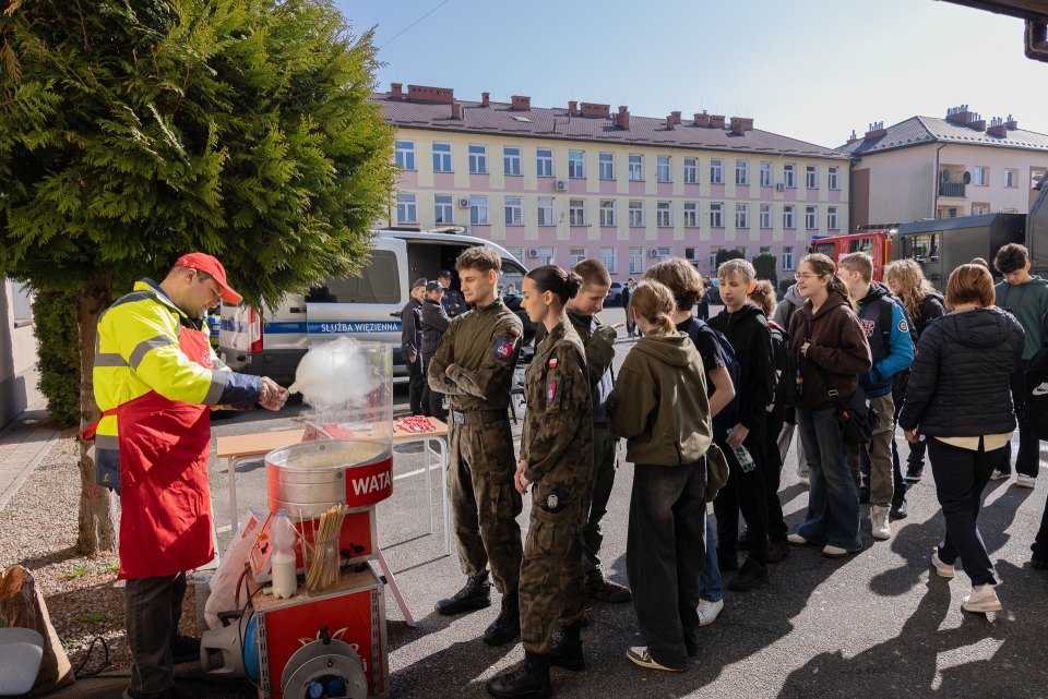 Uczestnicy dni otwartych przy stanowisku z watą cukrową.