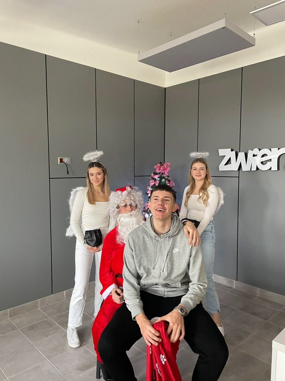 Pamiątkowa fotografia z Mikołajem na tle szkolnego napisu Zwierz.