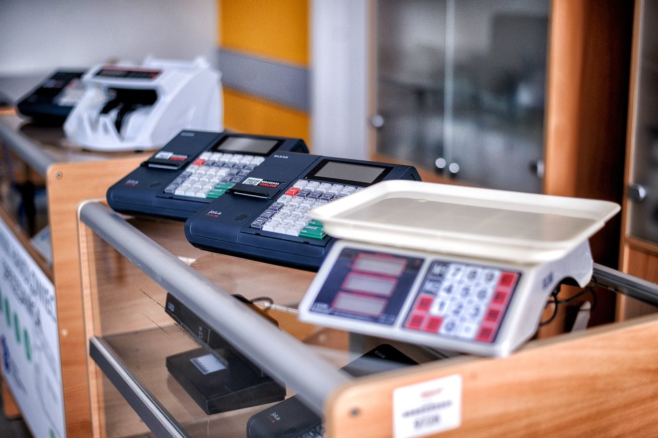 Kasa fiskalna i waga elektroniczna na ladzie ćwiczeniowej.