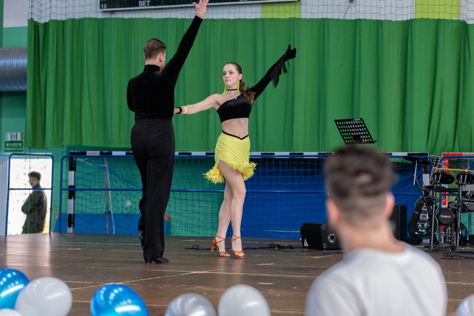 Para taneczna rozpoczyna występ na scenie w hali sportowej.